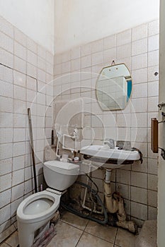 A dirty old toilet with a dirty toilet and sink