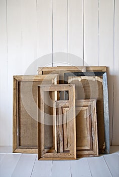 Dirty old vintage picture frames on the wall. White interior room