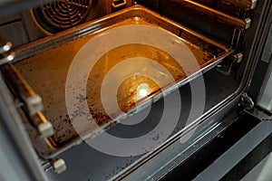 Dirty oven after cooking a greasy dish in the kitchen