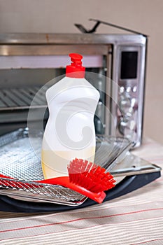 Dirty oven electric oven and items for washing and cleaning detergent sponge brush.