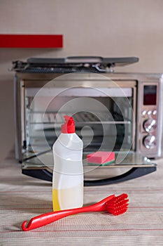 Dirty oven electric oven and items for washing and cleaning detergent sponge brush.