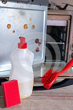 Dirty oven electric oven and items for washing and cleaning detergent sponge brush.