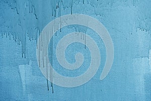 Dirty painted wall surface, flowing paint of blue bright color, texture. Abstract background