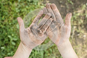 Dirty palms of the child. Dirty hands of a child in the ground.