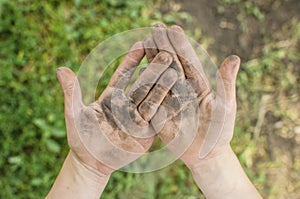 Dirty palms of the child. Dirty hands of a child in the ground.