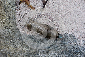 Dirty Plastic Bottle on a Sand Beach