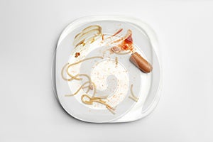 Dirty plate with food leftovers on white background
