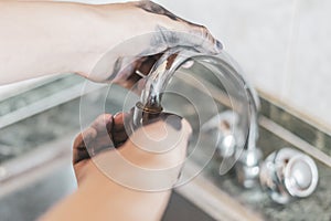 Dirty plumber hands repair a water crane tap f