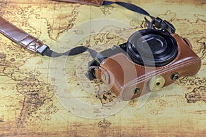 Dirty pocket compact camera on a old world map