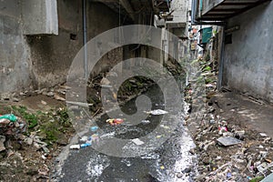 Dirty polluted waste water in big city with garbages. Environment pollution. Urban environment issues in developing countries