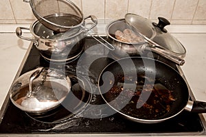 Dirty pots and pans are placed on a stainless steel electric stove on the galley on the ship