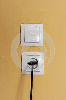 Dirty power outlet on a yellow wall