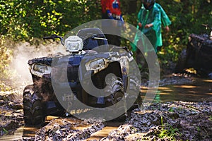 Dirty quad bike without a driver standing in the dirt on the track.