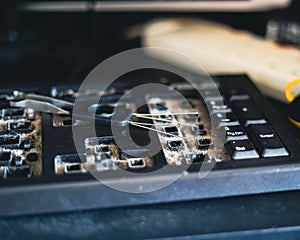 Dirty Qwerty keyboard full of dusts and debris on the table. Cleaning the computer