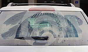 Dirty rear car windowwith wiper
