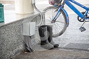 Dirty rubber boots beside old bicycle