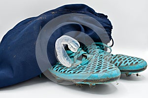 Dirty rugby gear on a white background. Rugby boots, shorts and gumshield mouthguard