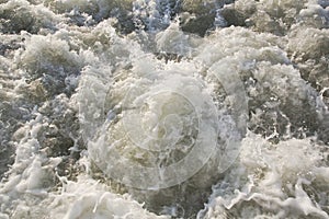 Dirty rushing water background of a river in flood