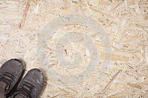 Dirty safety boots on plywood background. Concept of health and safety in construction industry