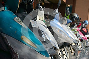 Dirty scooters parked at a street in an Asian city