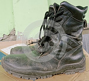 Dirty security work shoes are stored on top of used cardboard after use