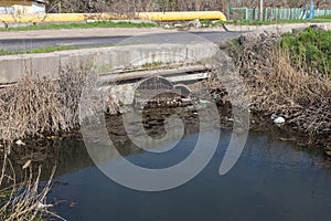 Dirty sewage and household rubbish in small river, irrigation channel causes rapid growth of algae. Water pollution. Ecological pr