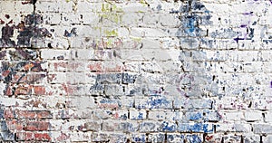 Dirty shabby painted brick surface, paints of different colors. Colorful grunge texture of wall