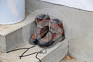 Dirty shoes stand on the porch of the house