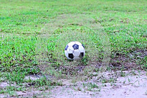 Dirty soccer ball in wet field