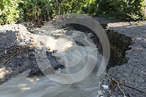 Dirty stream of a mountain river after rain and mudflow with soil erosion. Landslides and natural disasters concept