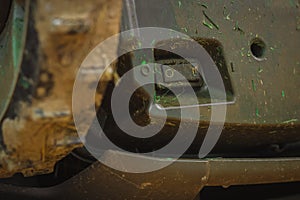 Dirty switch of robotic lawnmower, motorized lawnmower being serviced on a table after a year of use in the mud and grass. On-off