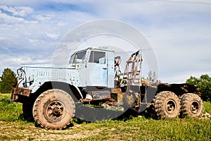 Dirty truck on a country green grass in a sunny summer day with blue sky