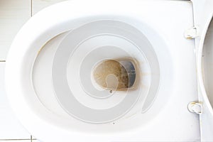 Dirty unhygienic toilet bowl with limescale stain at public restroom close up