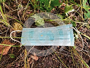 Dirty used medical mask laying on the ground