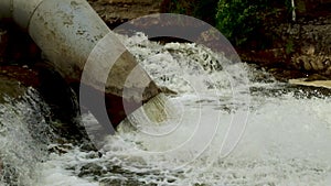 Dirty water and chemical waste are poured out of the pipe into a mountain river