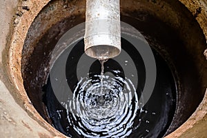 Dirty water flowing from pipe in sewer