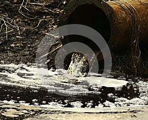Dirty water flows out of old rusty pipe without cleaning