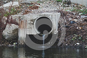 Dirty water flows out of the old rusty pipe without cleaning