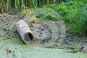 dirty water in the river. Environmental pollution. Construction waste. The asbestos pipe lies on the bank of the river. The world