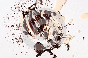 Dirty white background with melted chocolate and spilled cream