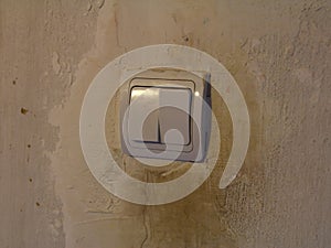 Dirty white light switch with dirty handprints on dirty white wall background
