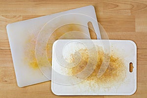 Dirty white plastic cutting board with dark stains, scratch