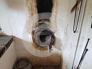 Dirty white wall with old oven and ashes