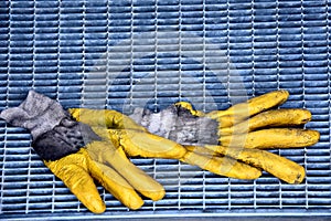 Dirty yellow work gloves on manhole cover