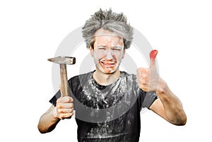 Dirty young builder guy fail is hold a hammer, hit the finger on a white  background at home during repairs