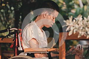 Disability child on wheelchair looking, talking with the girl doll