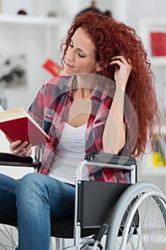 Disabilty and handicap young disabled woman on wheelchair reads book