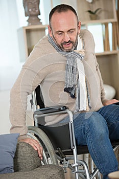 disable man trying to sit on sofa photo