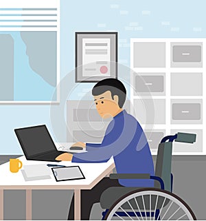 Handicapped businessman sitting on wheelchair and using computer in office.