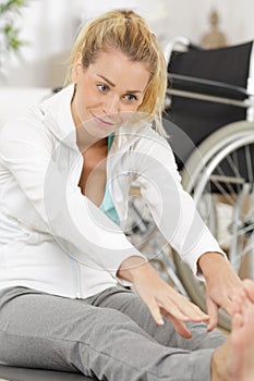 Disable woman stretching legs indoors